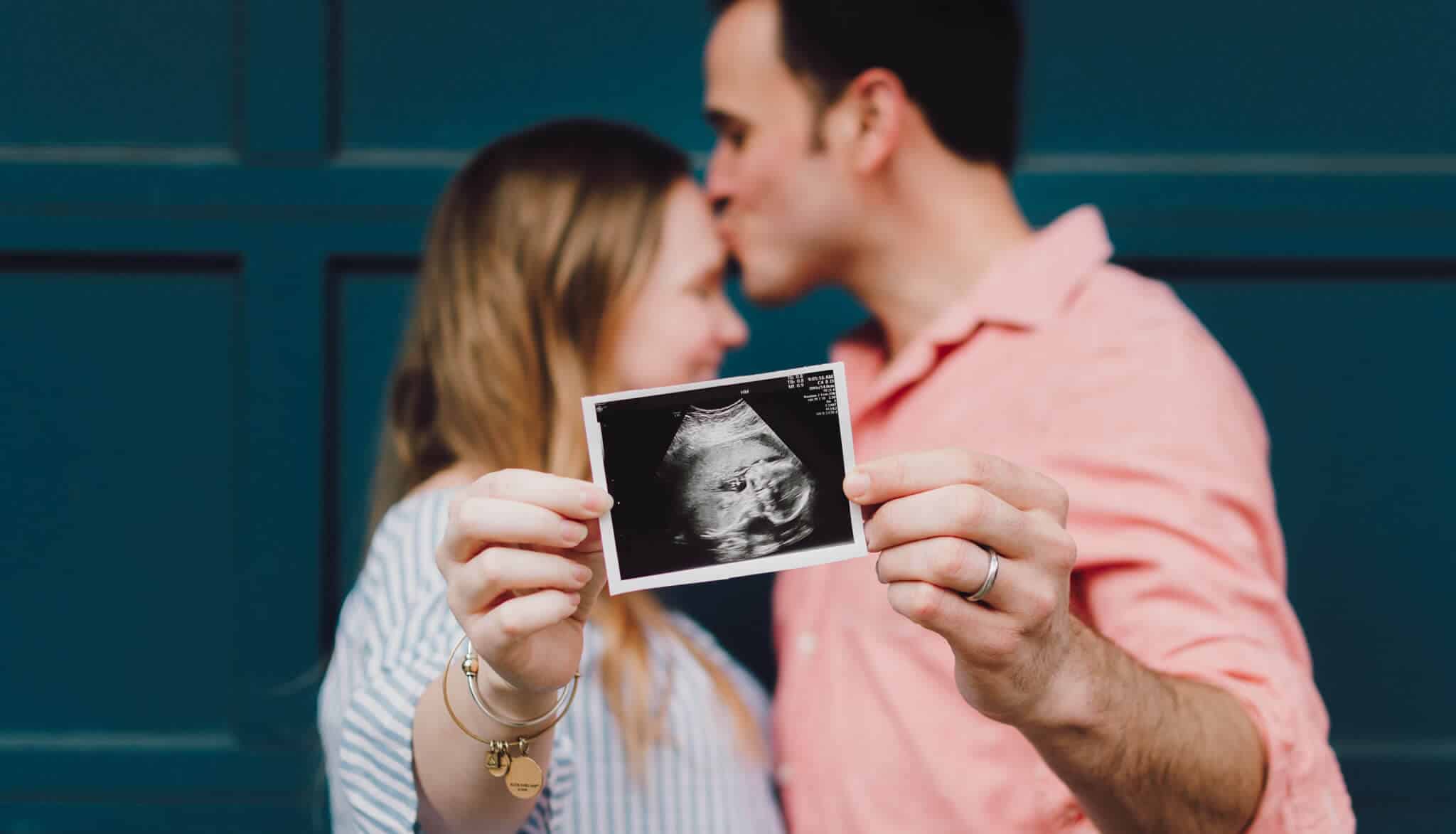 Paar mit Ultraschall-Bild, das Schwangerschaft nachweist
