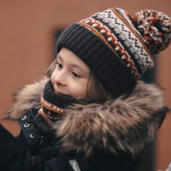 Kleines Kind mit Mütze und Winterjacke